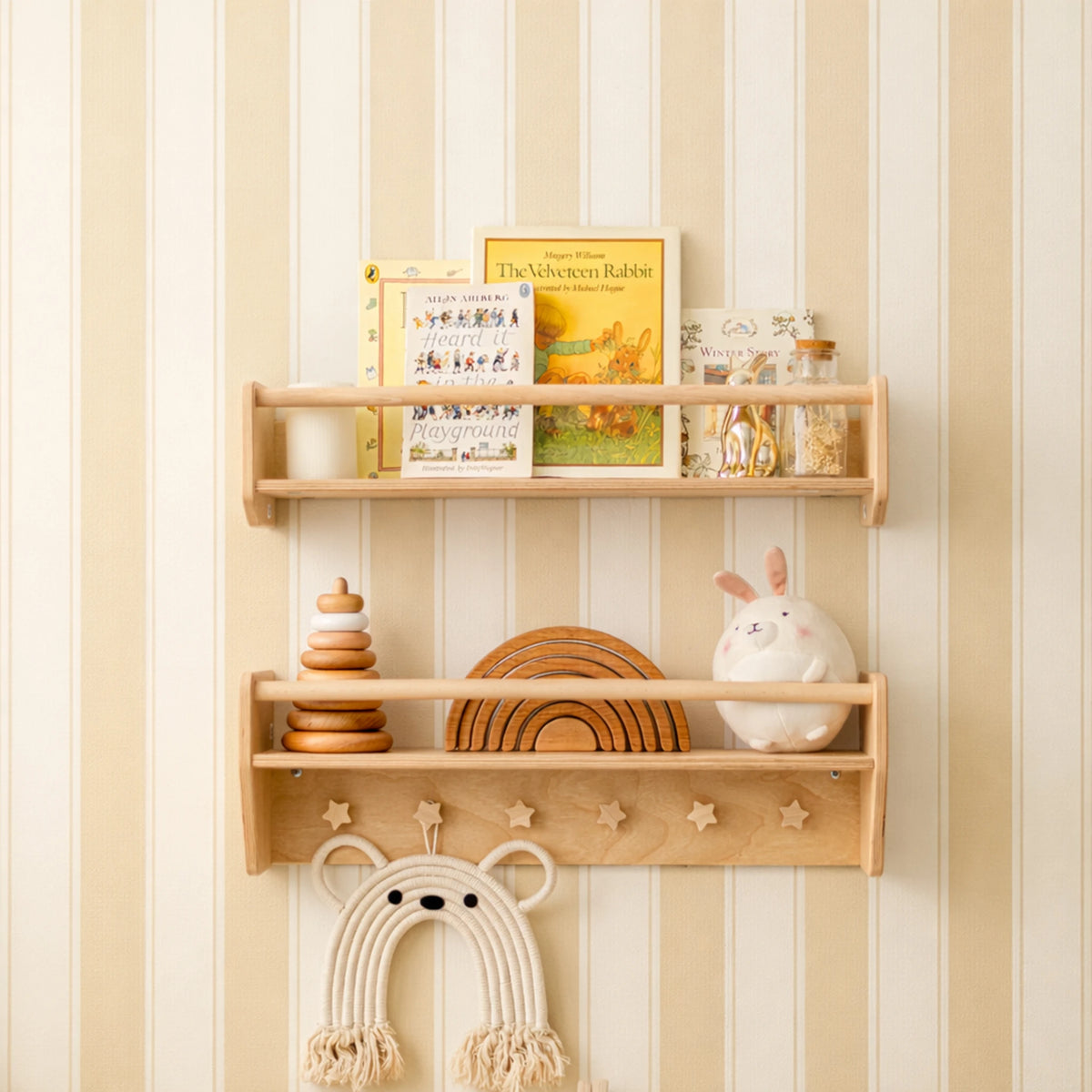 Light wood Montessori wall shelf set with star cut-outs, holding books, wooden toys and a macrame bear in a nursery