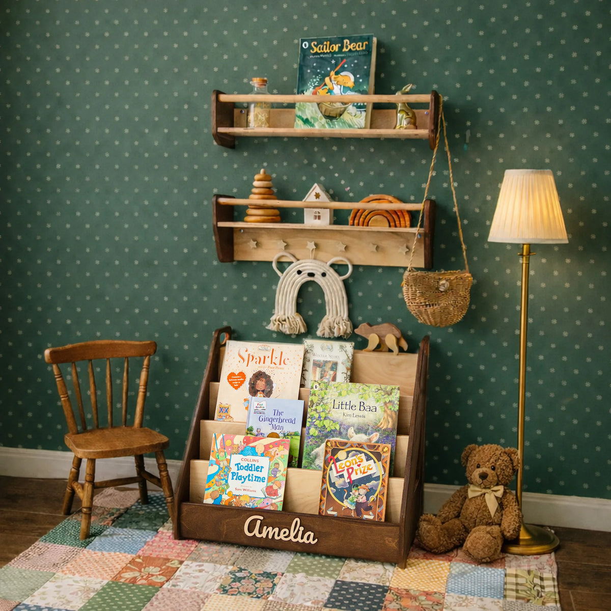 Dark wood Montessori bookshelf with 3D name in a green playroom with wall shelves