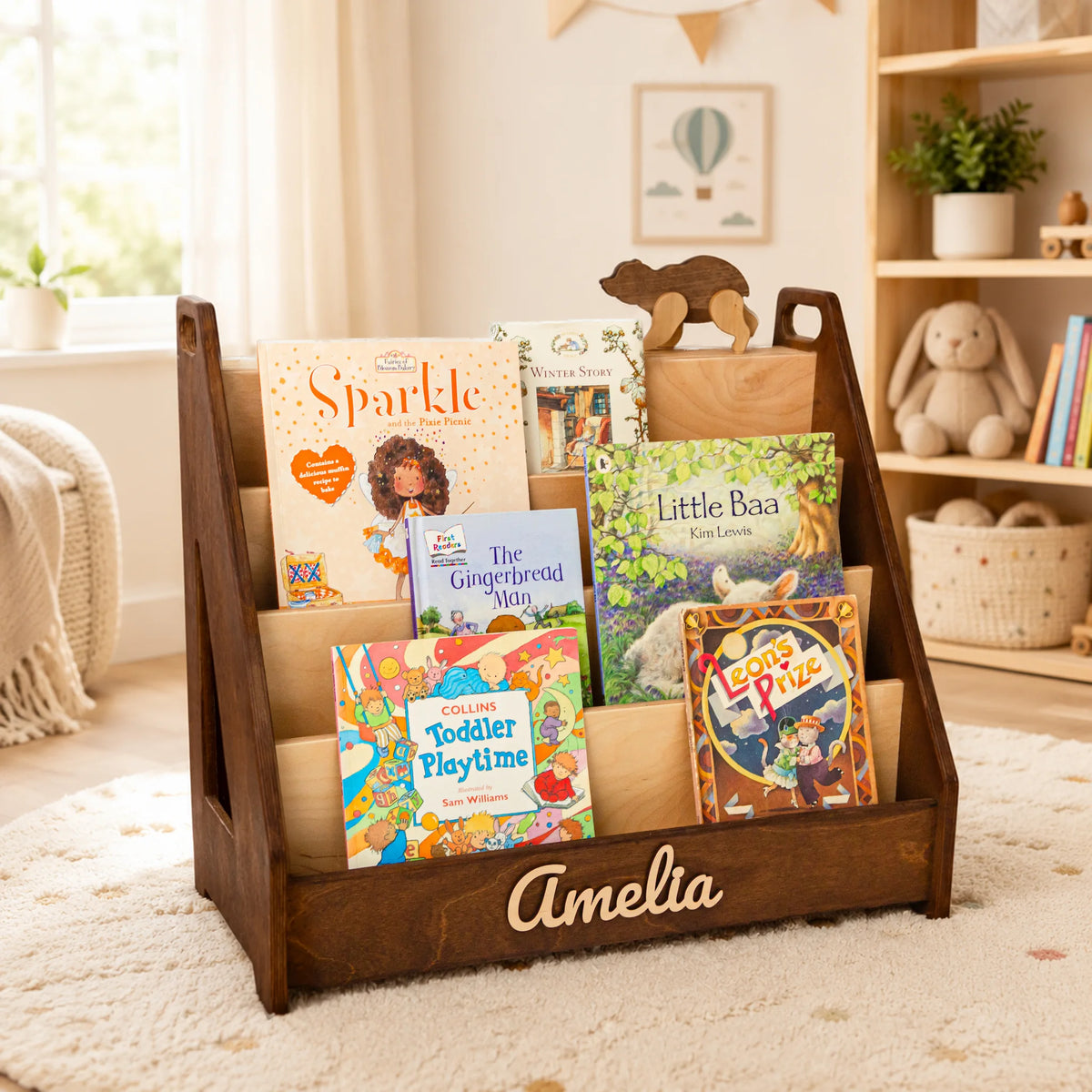 Dark wood Montessori front-facing bookshelf with name Amelia in a bright, sunlit kids room