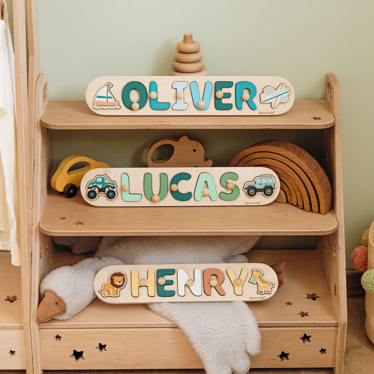 Name puzzles with the names Oliver, Lucas and Henry displayed on a wooden Montessori shelf