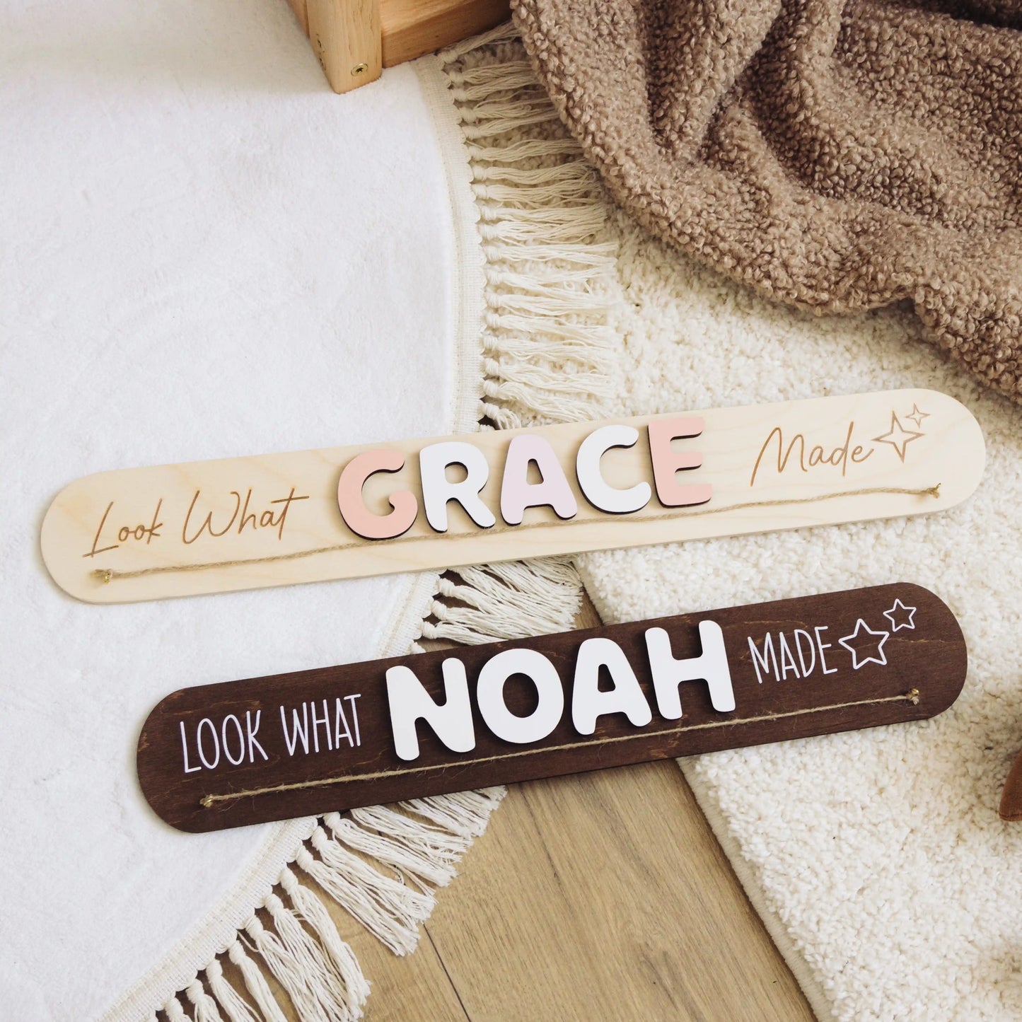 Dark wood Look What I Made signs with the names Grace and Noah on a woven blanket