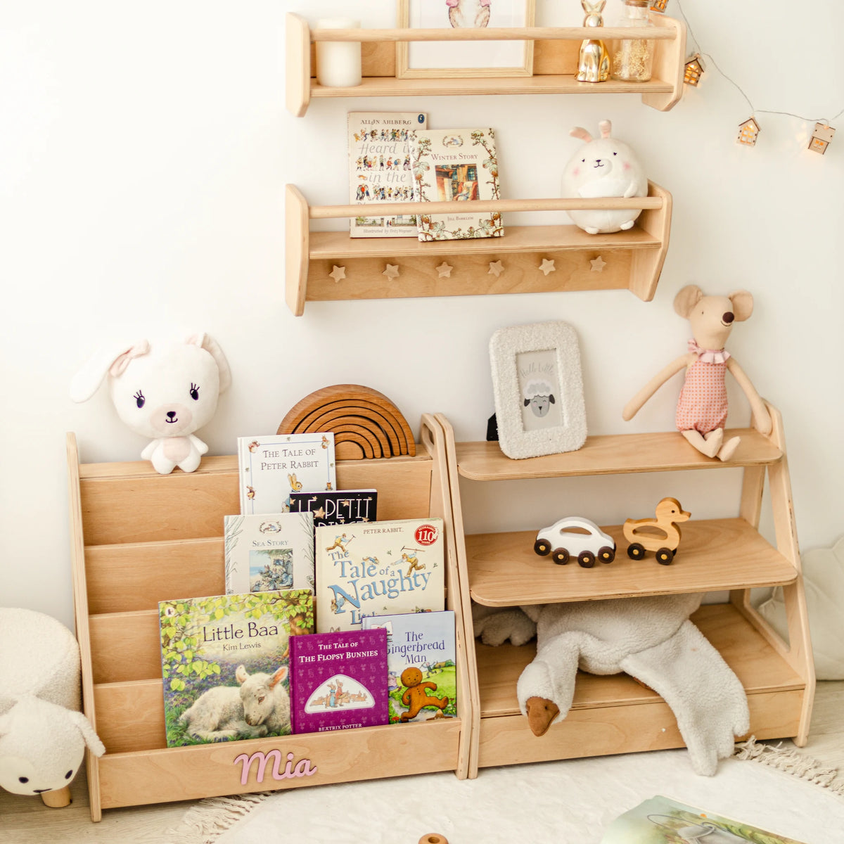 Light wood Montessori toy shelf and front-facing bookshelf standing side by side with toys and picture books