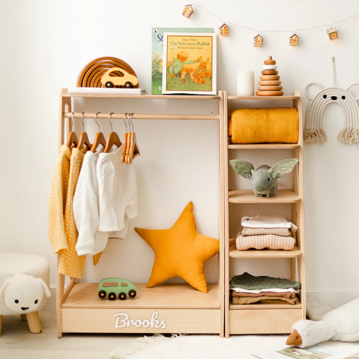 Personalized light wood Montessori clothing rack and shelf set styled with clothes and a star cushion, name Brooks