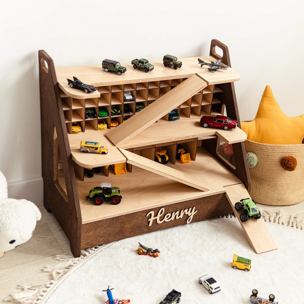 Dark wood toy car garage with the name Henry, cars parked on shelves and ramp
