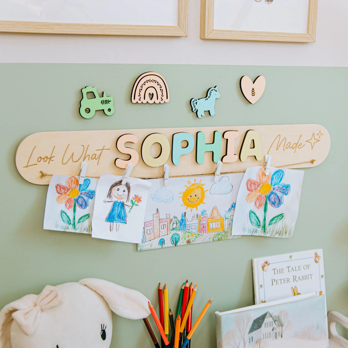 Look What I Made sign with the name Sophia in pastel letters and a rainbow piece on a green nursery wall