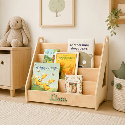 Light wood Montessori bookshelf with name Liam styled in a nursery corner with a teddy bear and cabinet