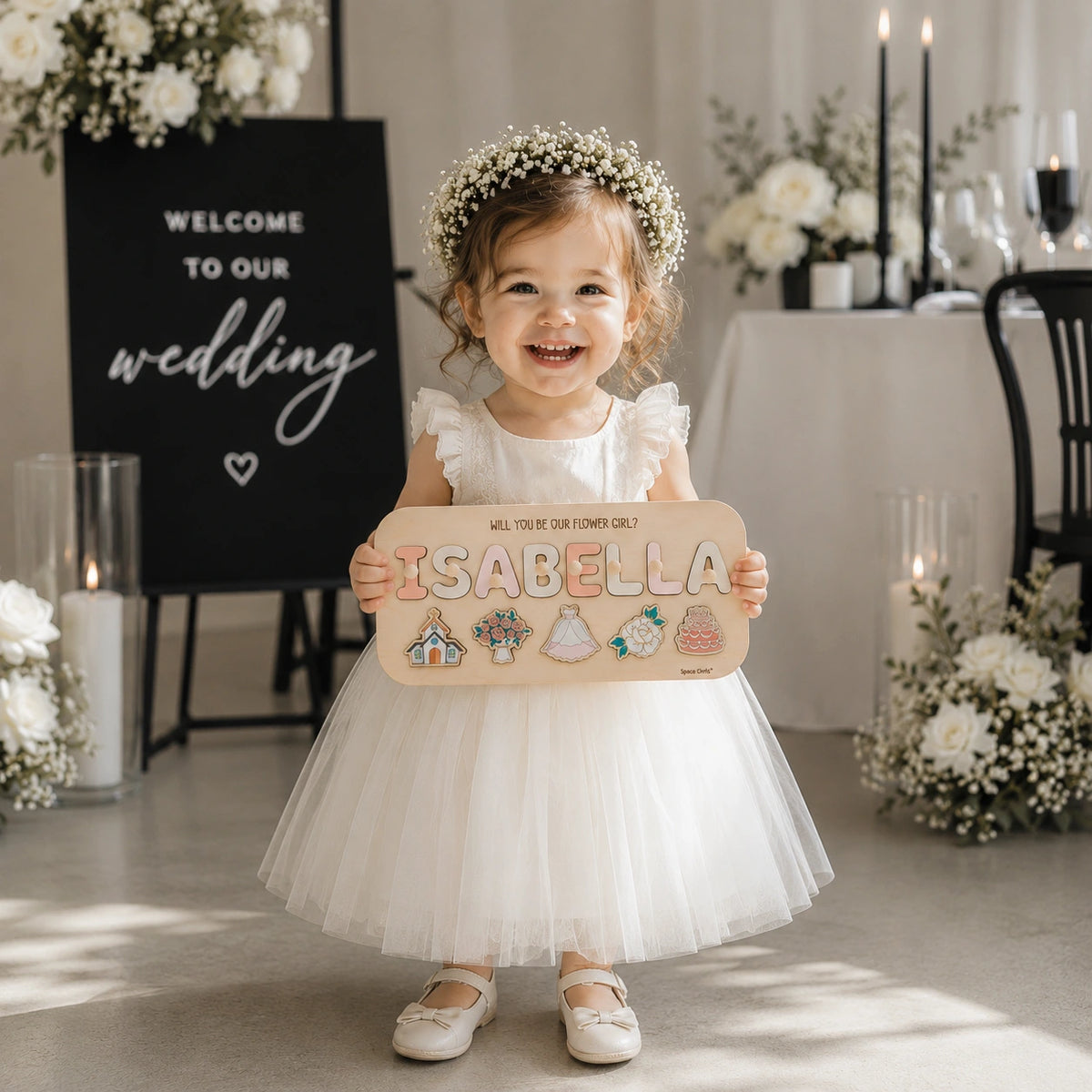 Flower girl holding personalized Isabella proposal puzzle at wedding
