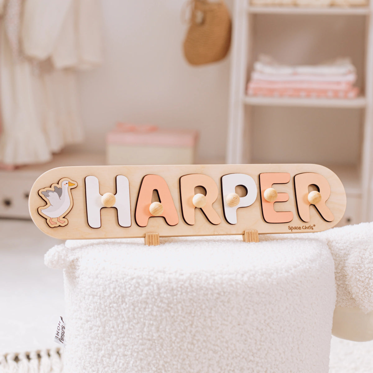 Wooden name puzzle with the name Harper and a swan piece standing on a shelf