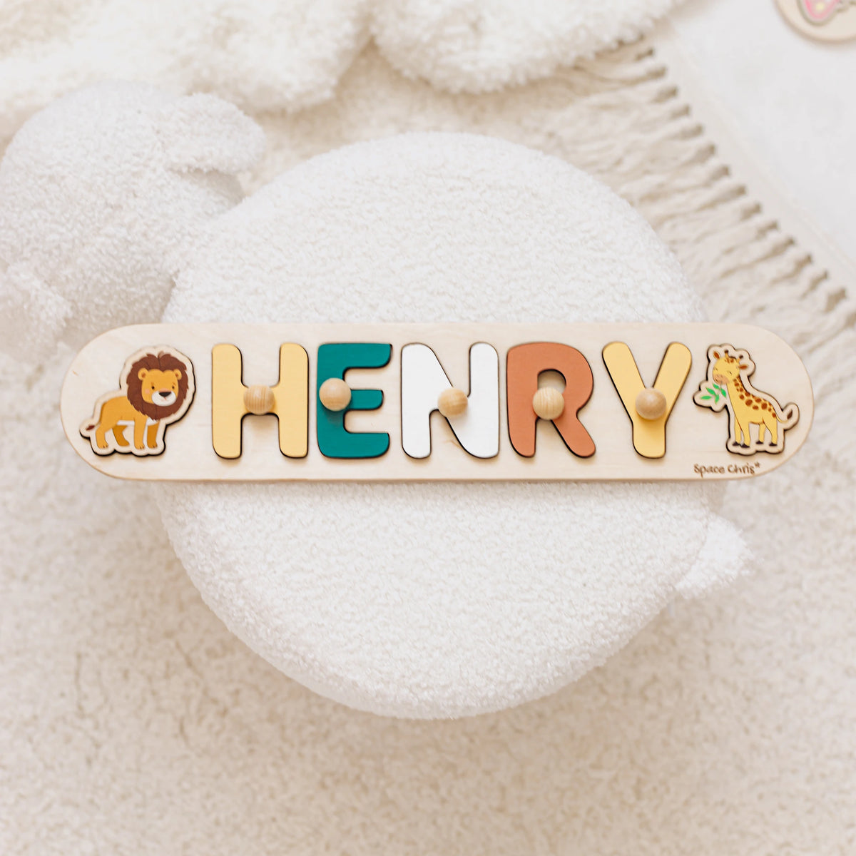 Name puzzle with the name Henry, a lion and a giraffe side element on a soft cushion
