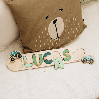 Name puzzle with the name Lucas and a monster truck piece on a bear cushion