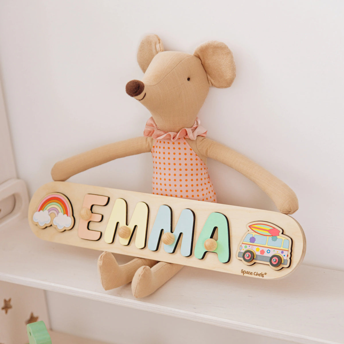 Wooden name puzzle with the name Emma and a camper van piece on a nursery shelf