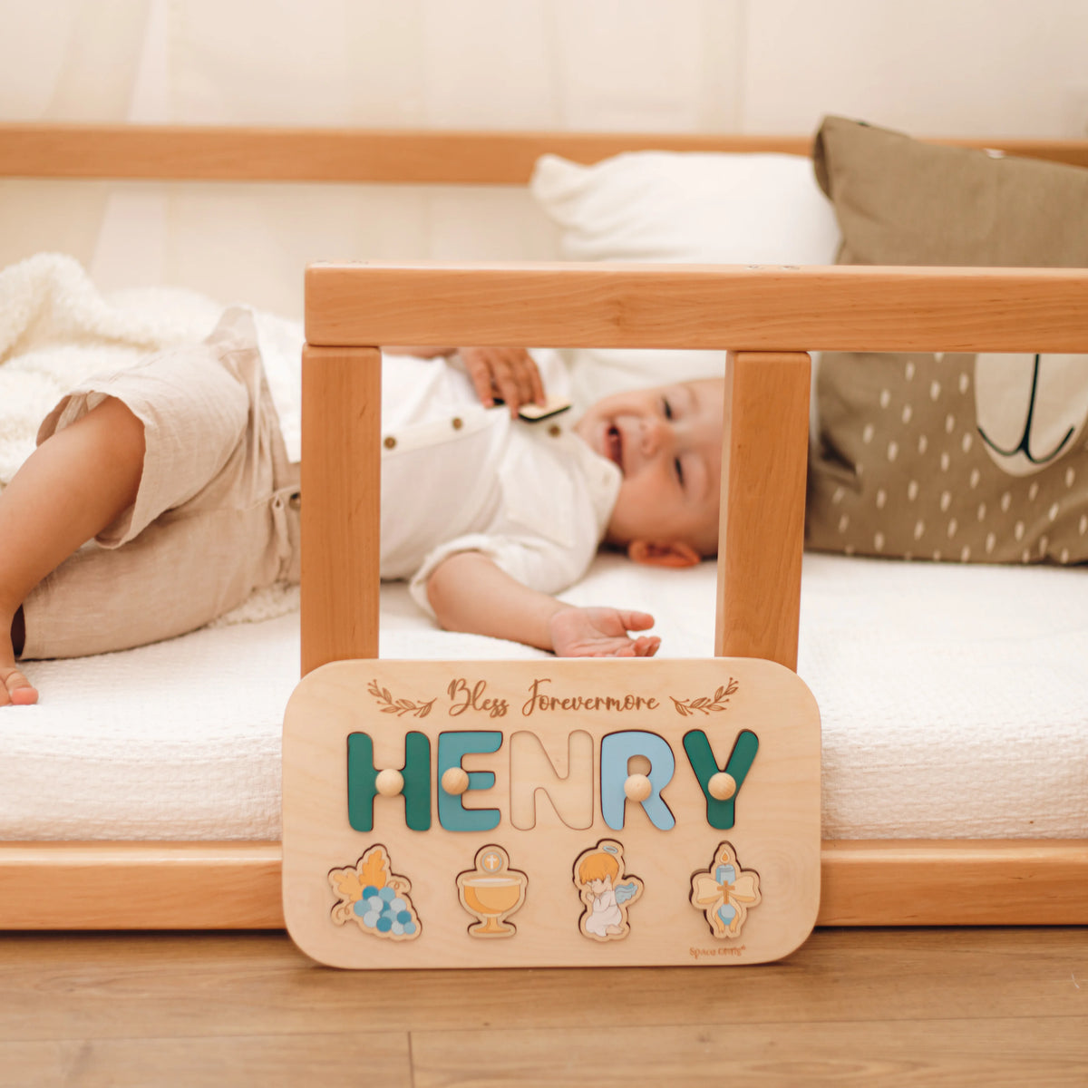Baby near personalized Henry baptism name puzzle in crib