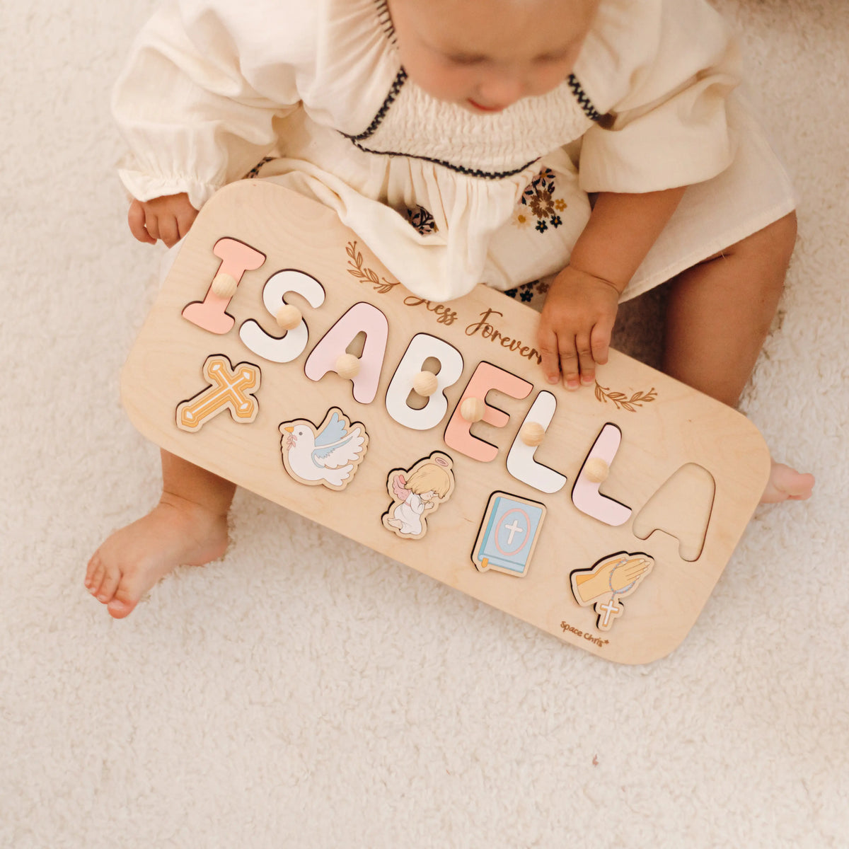 Baby holding personalized Isabella baptism name puzzle