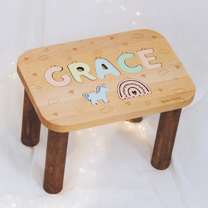 Custom wooden name stool for girls featuring pastel letters and cute puzzle cutouts.