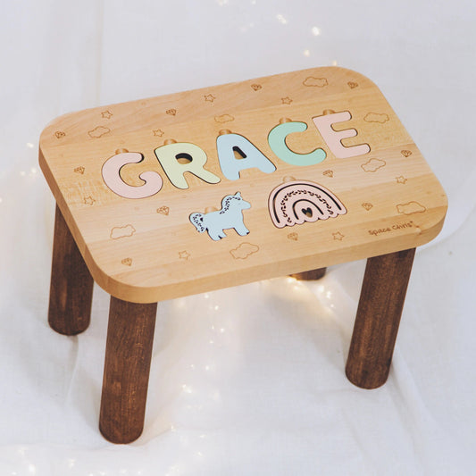 Custom wooden name stool for girls featuring pastel letters and cute puzzle cutouts.