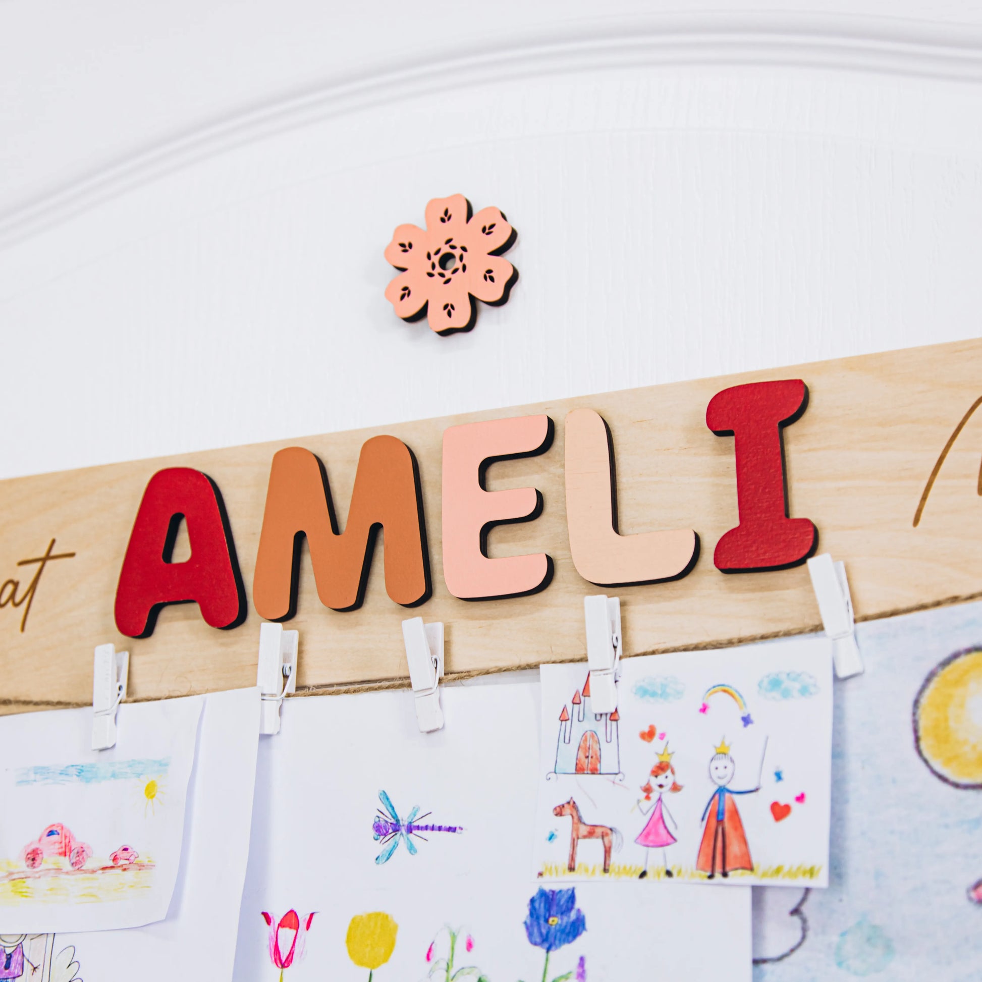 Look What I Made sign with the name Ameli in red letters holding a child's colorful drawings