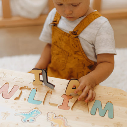 Close up of a toddler playing with chunky wooden letters on his custom name puzzle step stool.