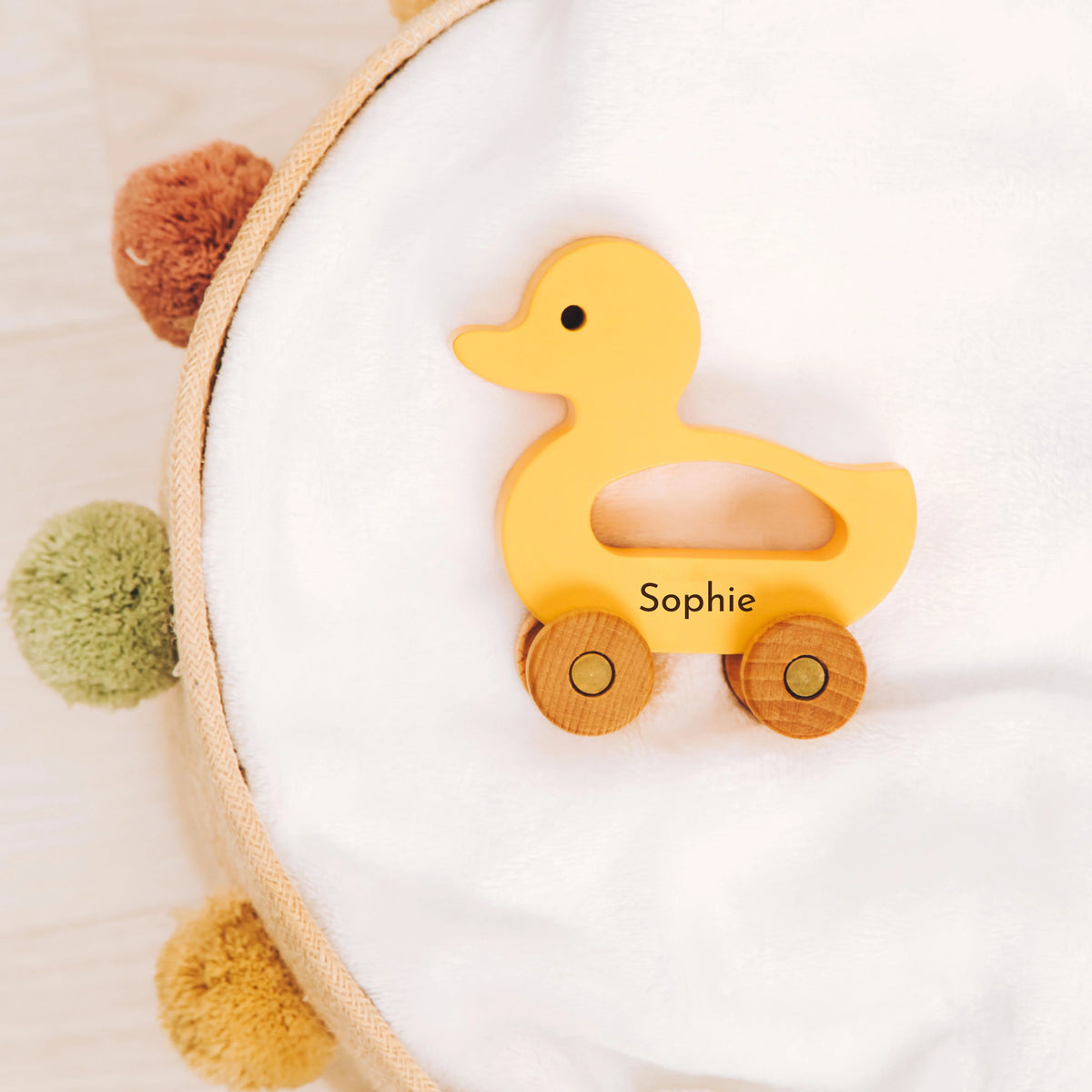 Personalized yellow wooden duck toy with name Sophie as nursery decor