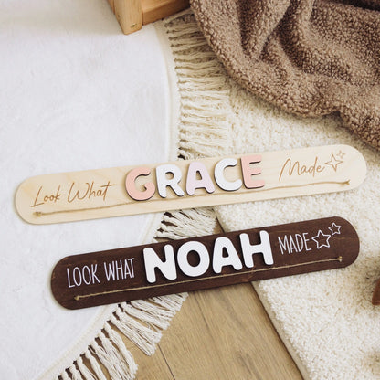Dark wood Look What I Made signs with the names Grace and Noah on a woven blanket