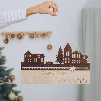 Hand hanging a personalized wooden City design advent calendar on the wall