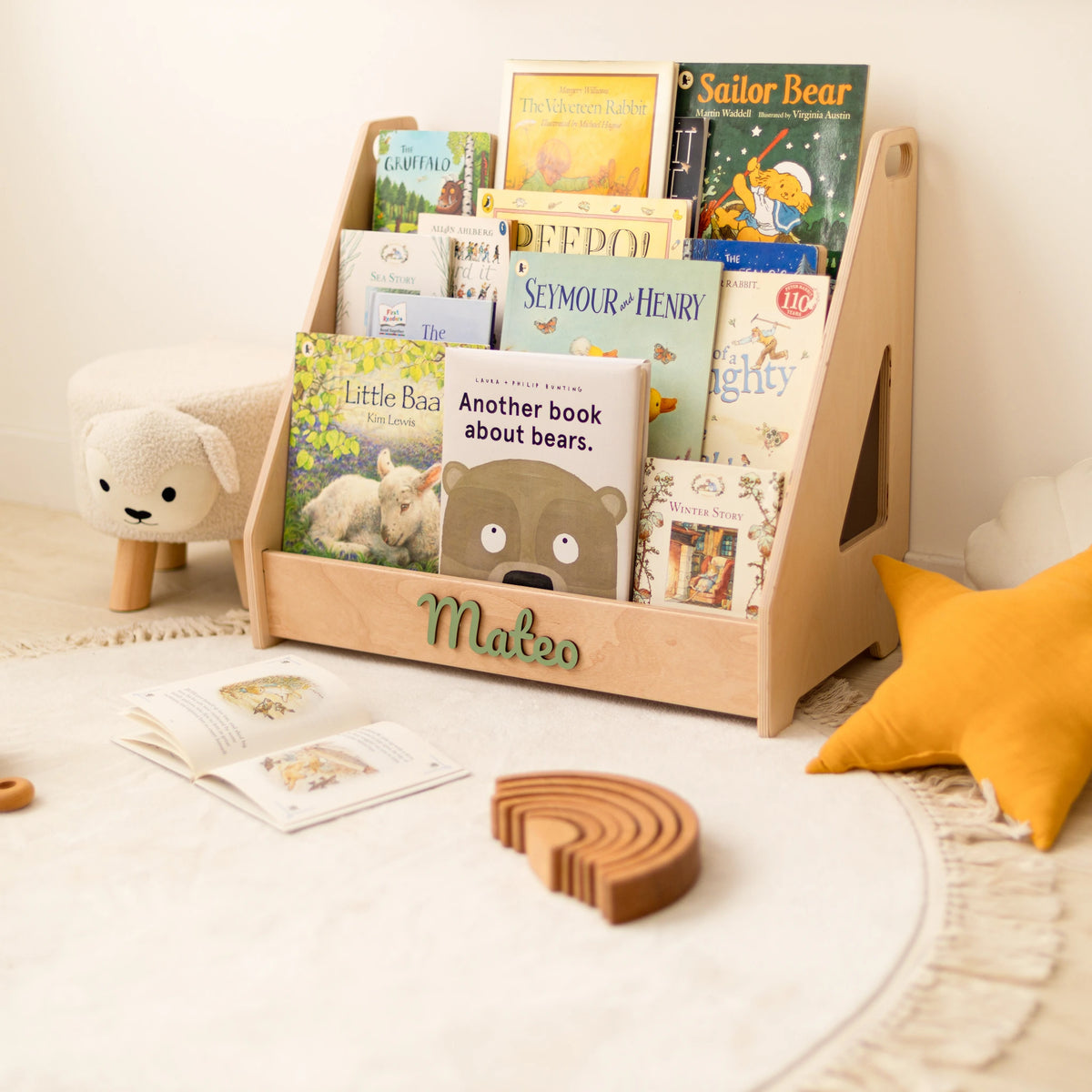 Light wood Montessori bookshelf with 3D name Mateo and a wooden rainbow stacker on the rug
