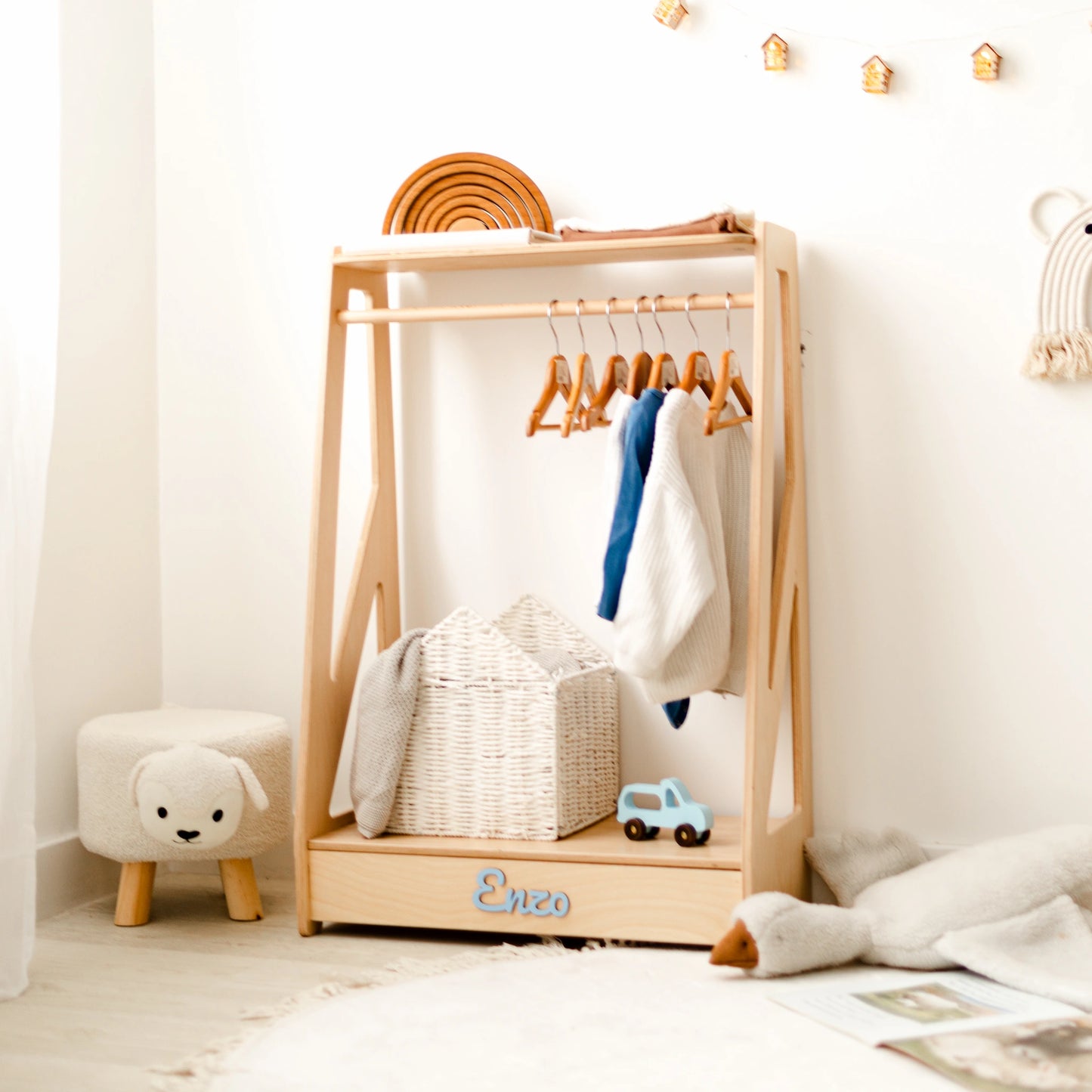 Light wood kids' clothing rack with clothes on wooden hangers and a small stool, name Enzo