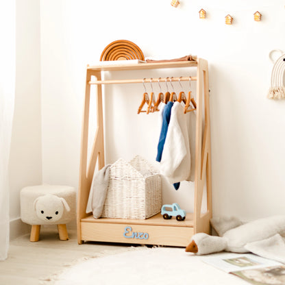 Light wood kids' clothing rack with clothes on wooden hangers and a small stool, name Enzo