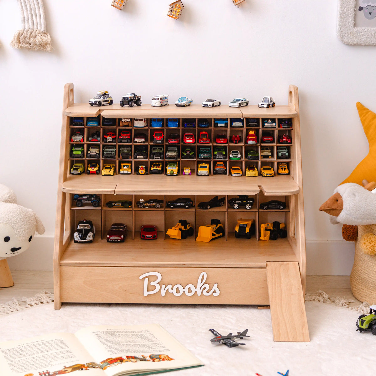 Light wood toy car garage with 70 storage cells and white 3D name Brooks on a white rug