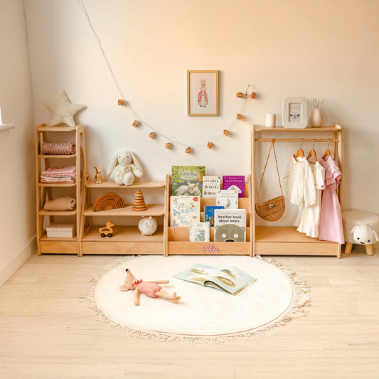 Light wood Montessori furniture set styled in a nursery with books, toys and a round rug