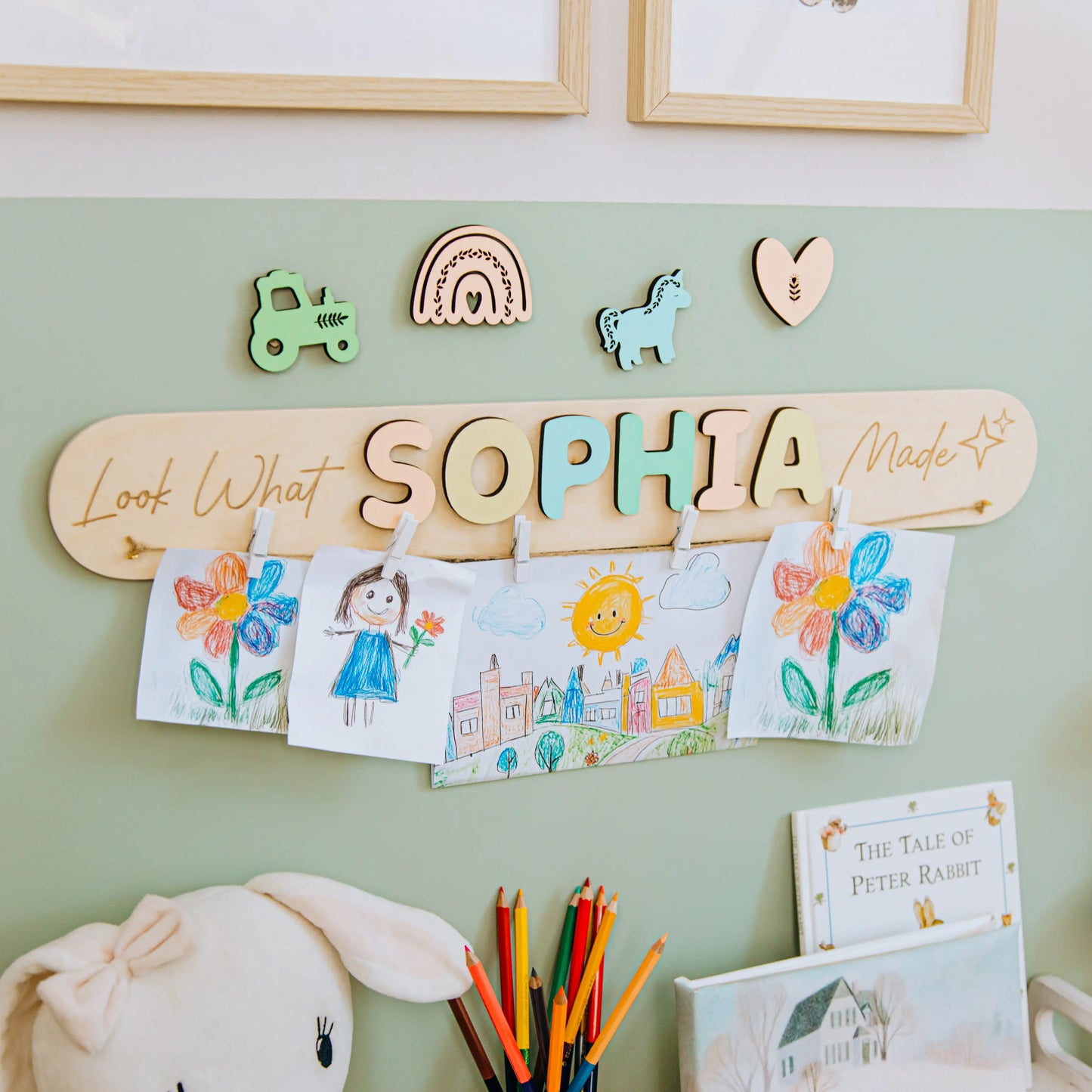 Look What I Made sign with the name Sophia in pastel letters and a rainbow piece on a green nursery wall