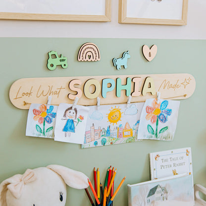 Look What I Made sign with the name Sophia in pastel letters and a rainbow piece on a green nursery wall