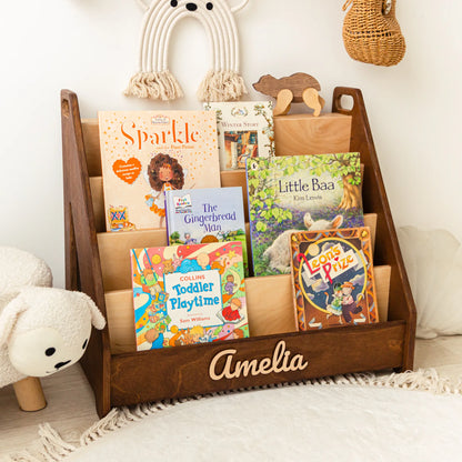 Front view of a dark wood kids' bookshelf with four tiers and 3D name Amelia