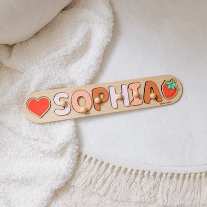 Name puzzle with the name Sophia and a heart piece on a white blanket